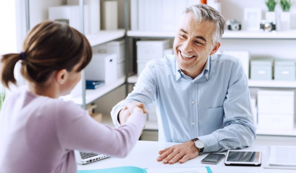 Happy young candidate shaking hands with her employer after a job interview, employment and business meetings concept